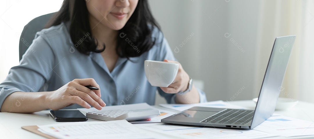 Mulher sentada trabalhando no computador e calculadora