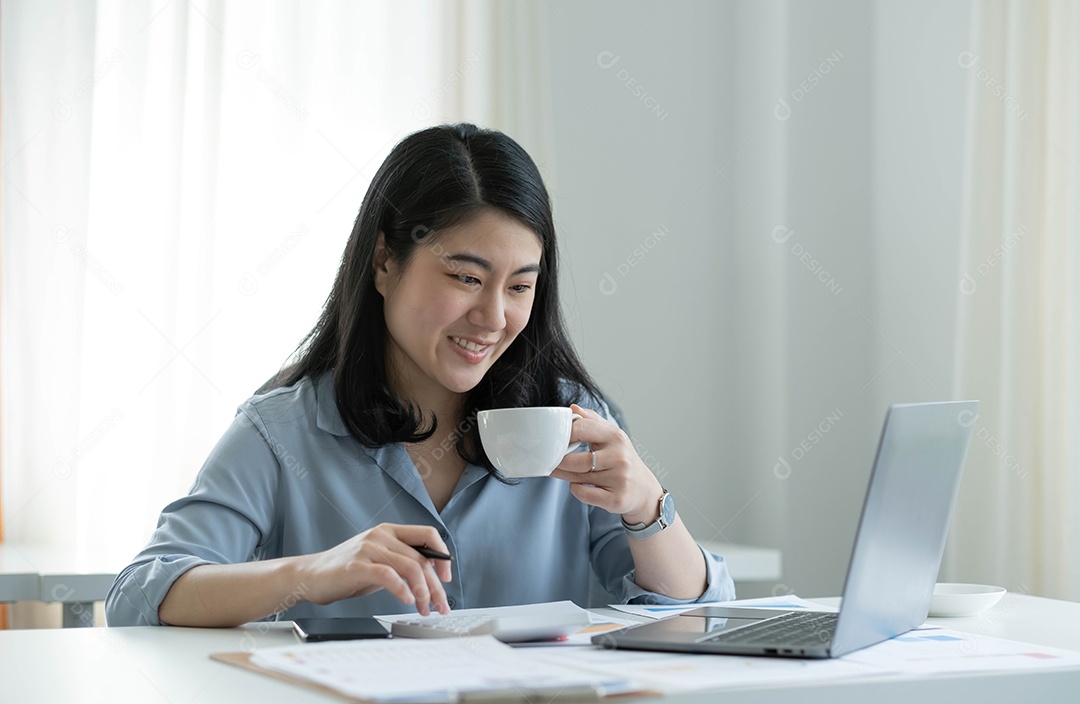 Mulher asiática sentada no seu local de trabalho