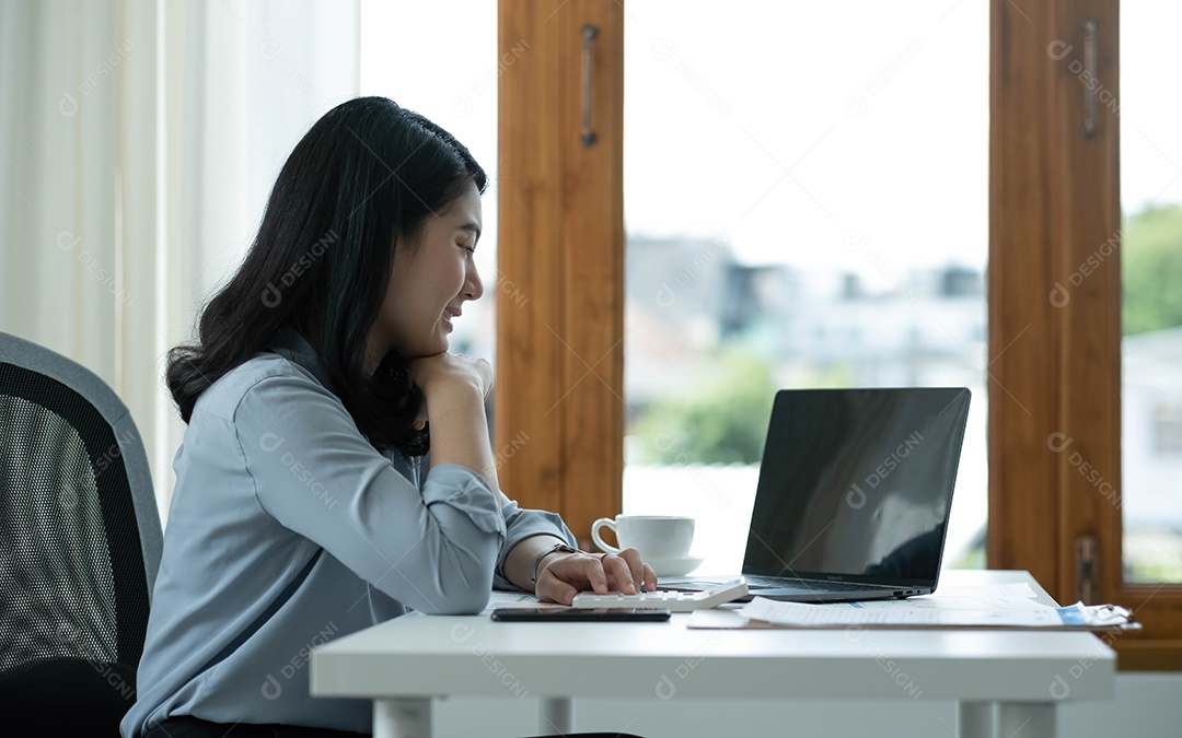 Mulher asiática sentada no seu local de trabalho