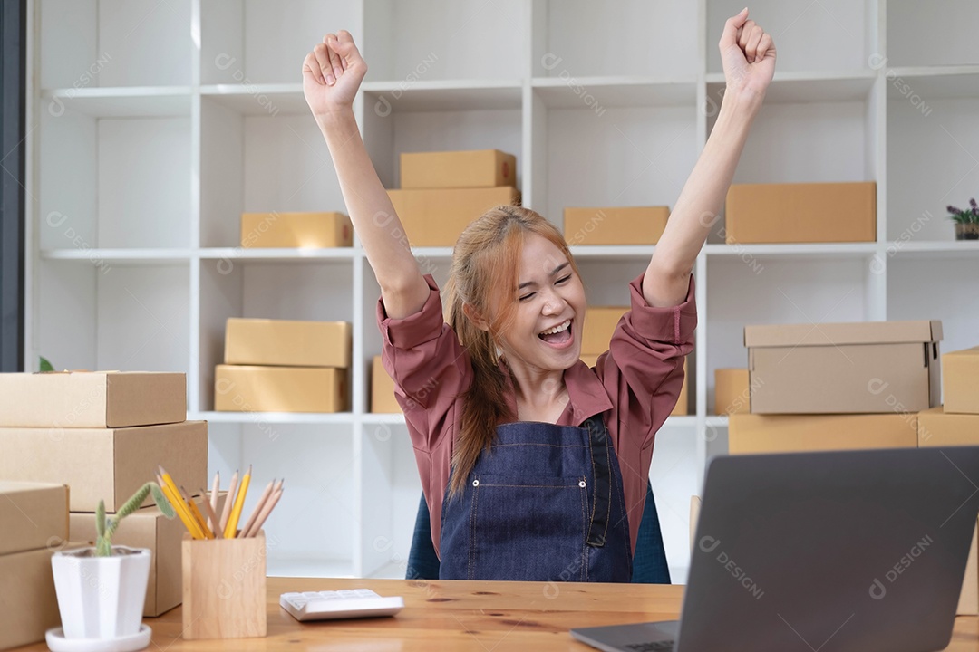 Feliz jovem empresária asiática, sorrindo para o sucesso de vendas