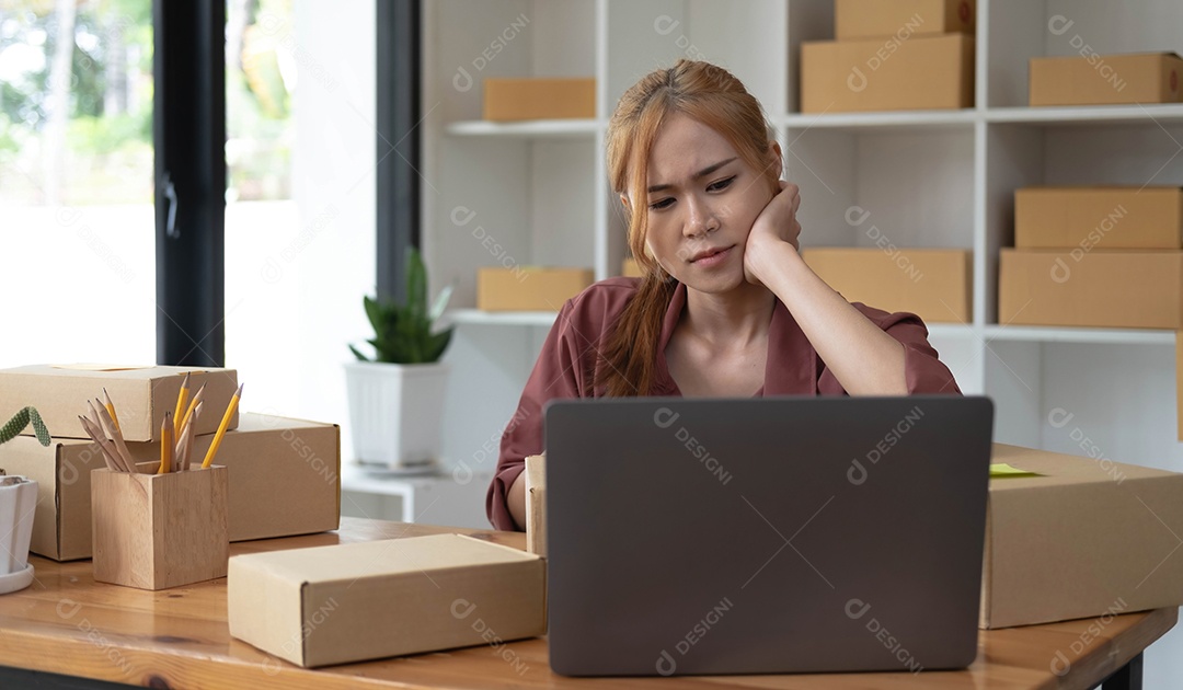 Um retrato de uma jovem asiática séria trabalhando com laptop