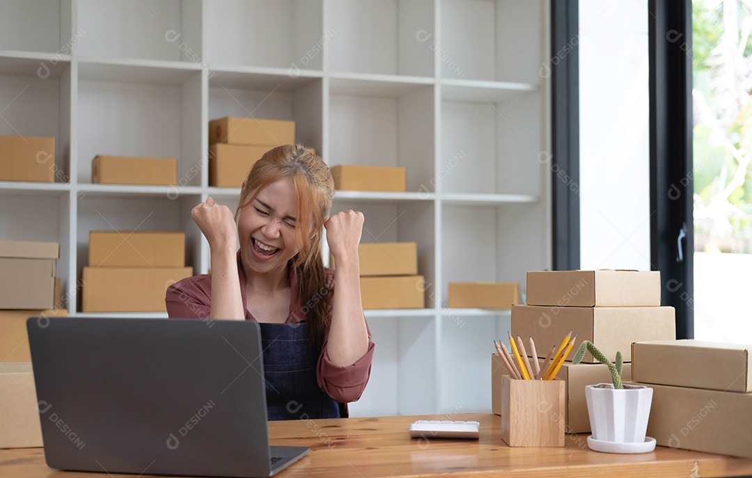 Feliz jovem empresária asiática, sorrindo para o sucesso de vendas