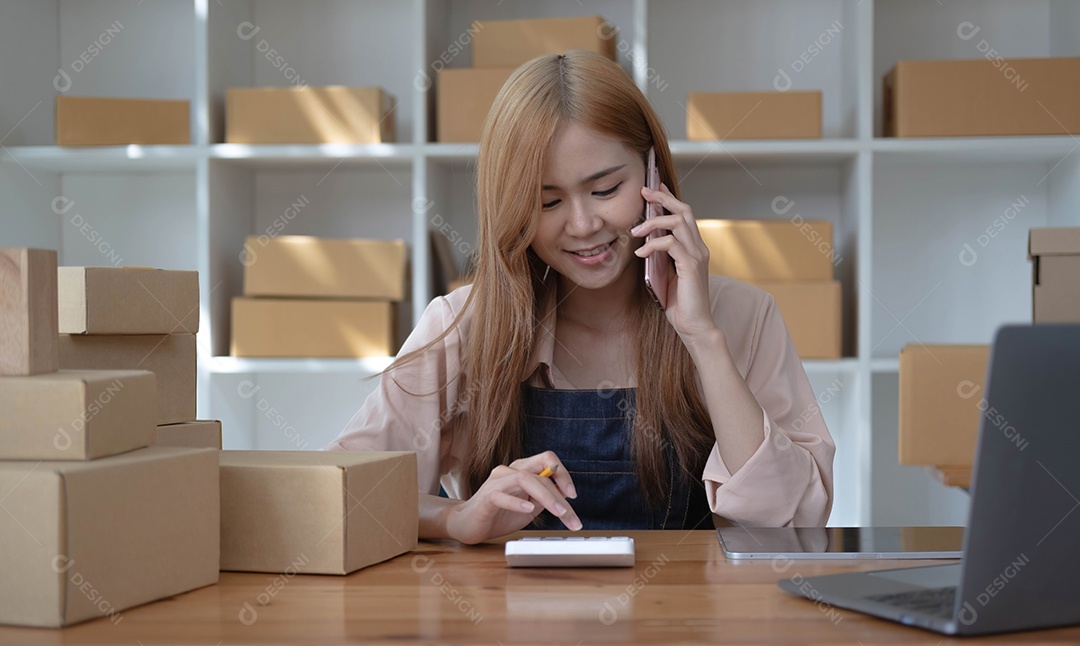 Proprietários de pequenas empresas iniciantes usando computadores e telefones no trabalho