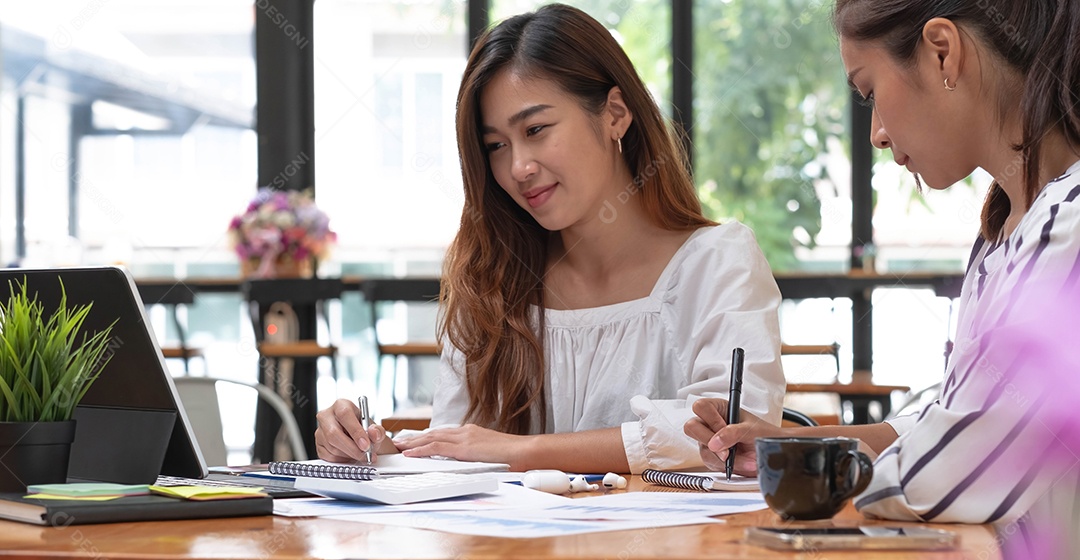 Duas belas mulheres de negócios asiáticos na conversa, trocando ideias no trabalho.