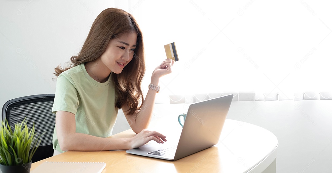 Mãos de mulheres de pagamento on-line segurando um cartão de crédito e usando laptop para compras on-line