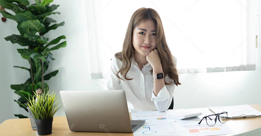 Encantadora mulher asiática trabalhando no escritório usando um laptop