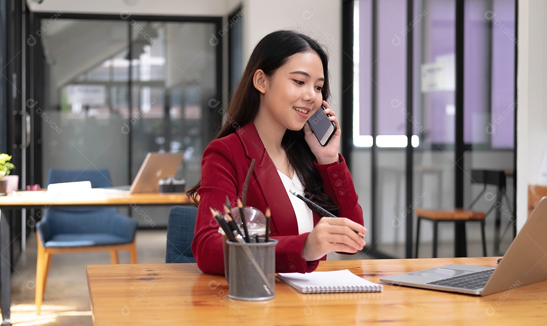 A mulher de negócios asiática tem a alegria de falar ao telefone