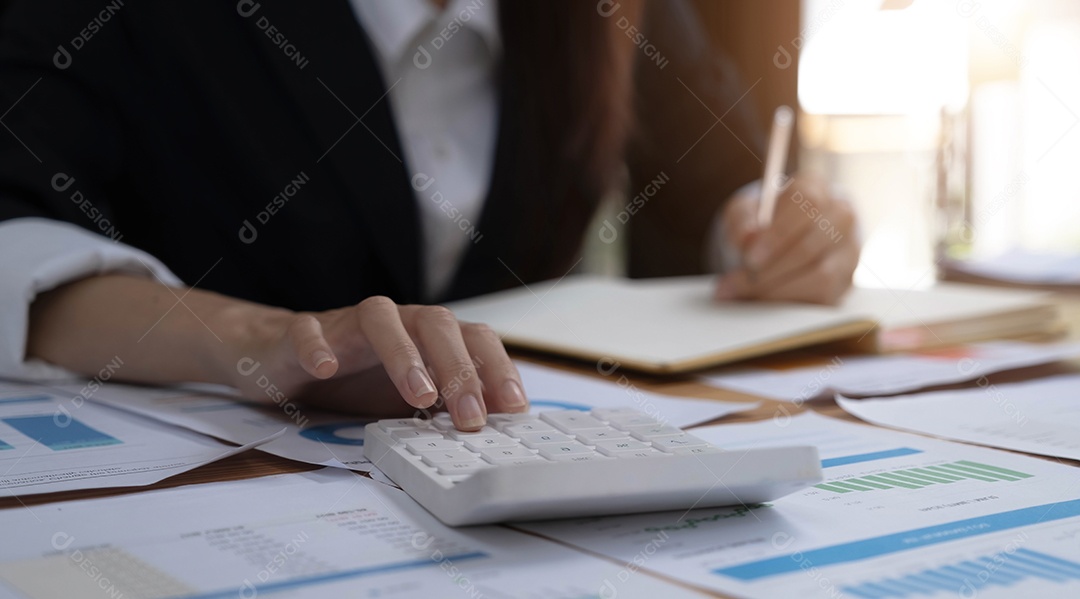 Mulher de negócios segurando calculadora e caneta e pondo o dedo no gráfico de estatísticas de crescimento