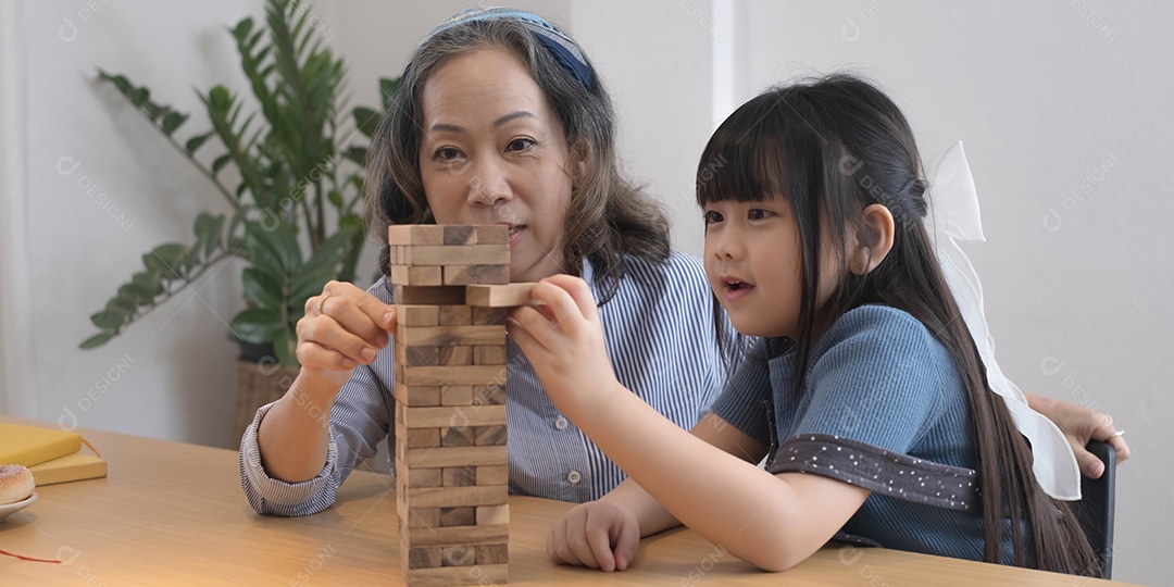 Menina com sua avó jogando jogo jenga em casa