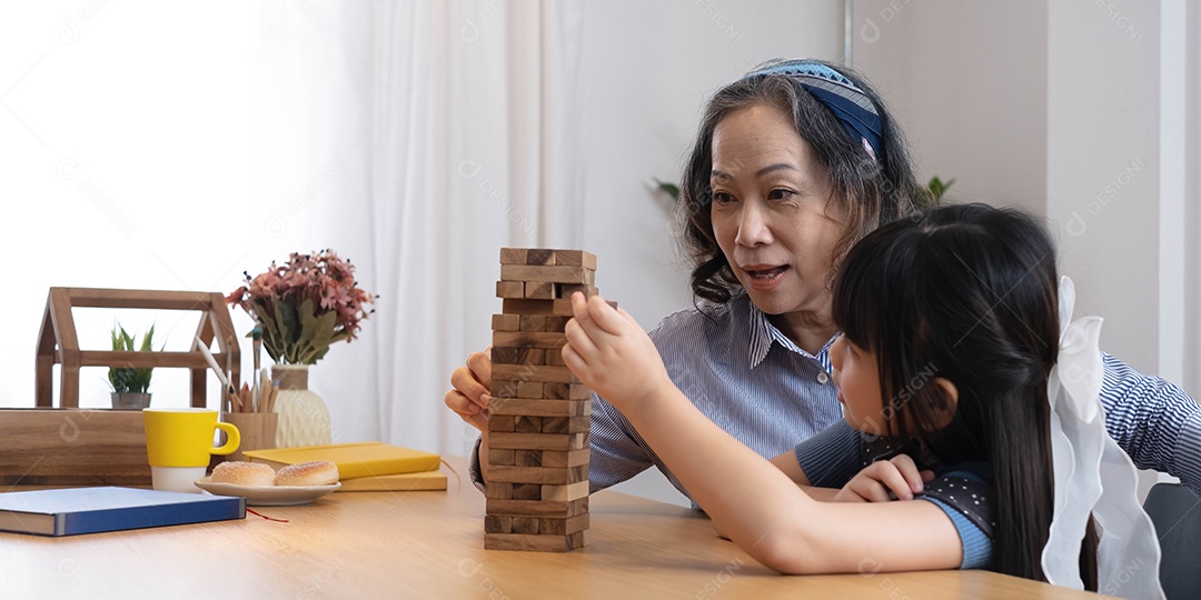 Menina com sua avó jogando jogo jenga em casa