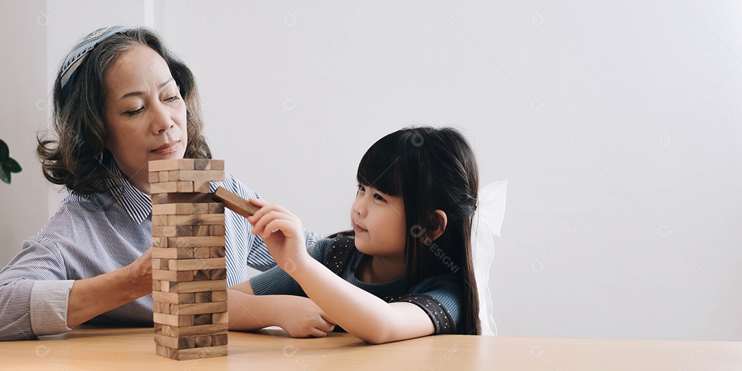 Menina com sua avó jogando jogo jenga em casa