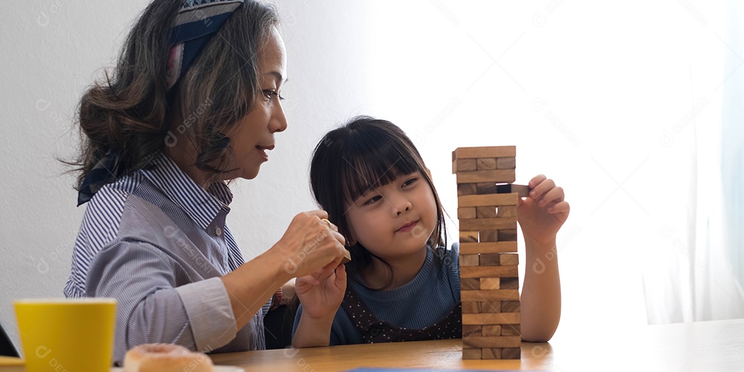 Menina com sua avó jogando jogo jenga em casa