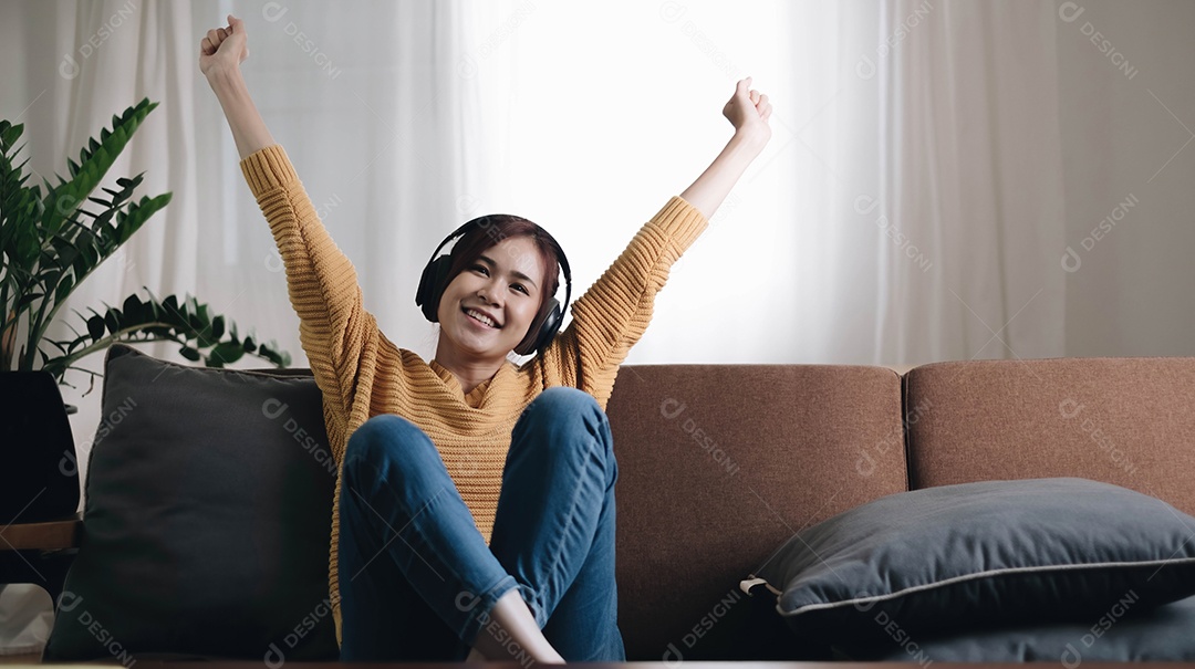 Uma jovem muito feliz rindo e ouvindo música e usando fones de ouvido