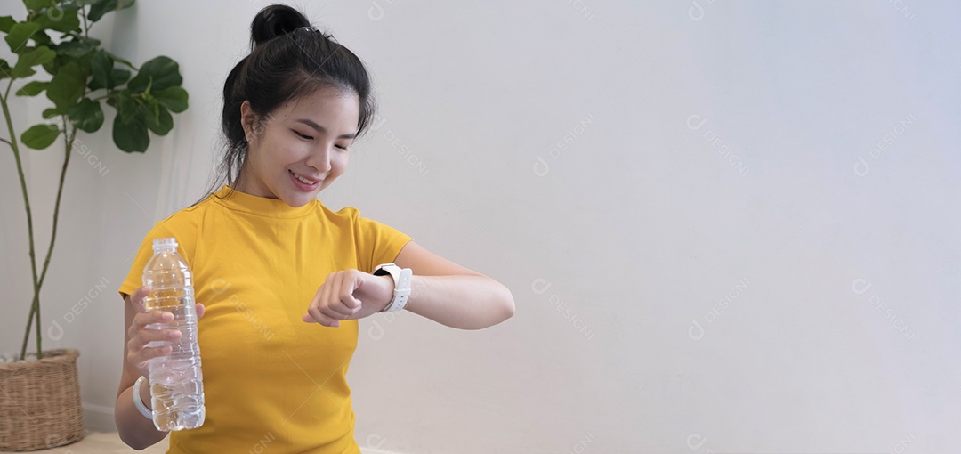 Jovem se hidratando depois de fazer exercícios em casa