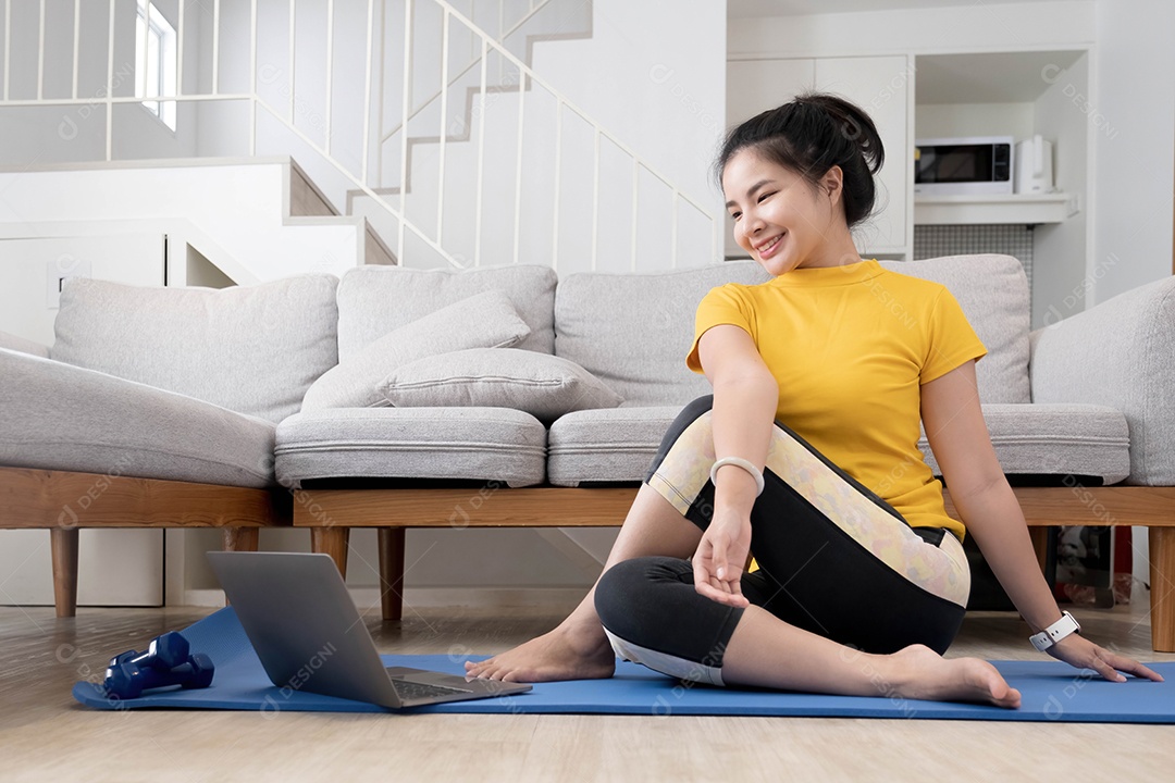 Jovem praticando exercícios em casa com as pernas entrelaçadas