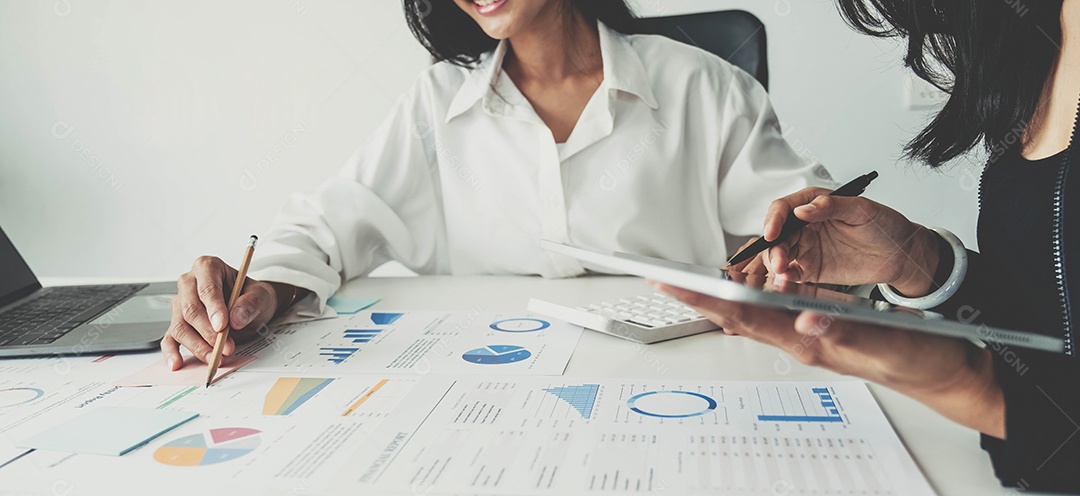 Equipe de negócios analisando gráficos de renda e gráficos com computador portátil moderno.