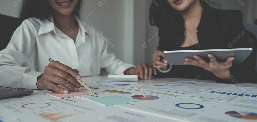 Grupo de empresários reunidos Apontando para o gráfico avaliam os lucros do negócio.