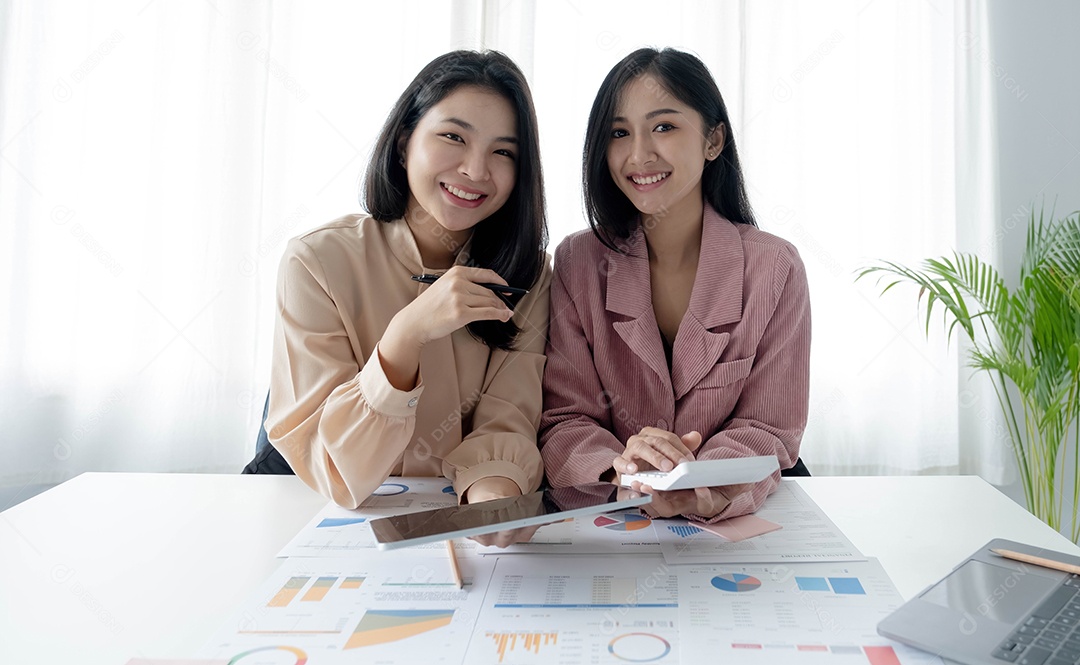 Duas empresárias trabalhando no escritório usando calculadora