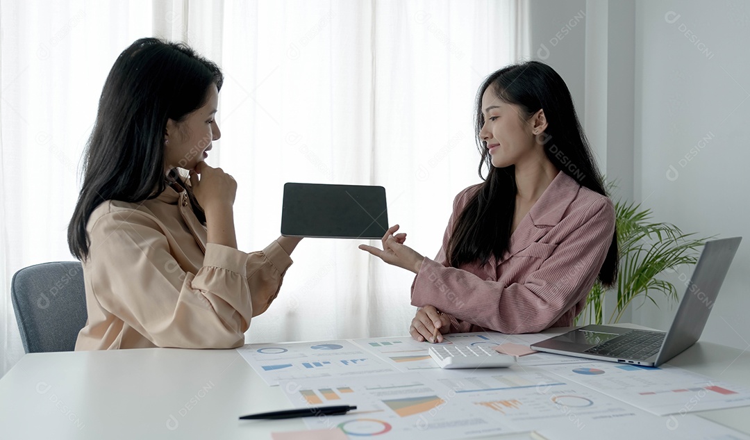 Duas empresárias trabalhando no escritório segurando tablet com tela preta