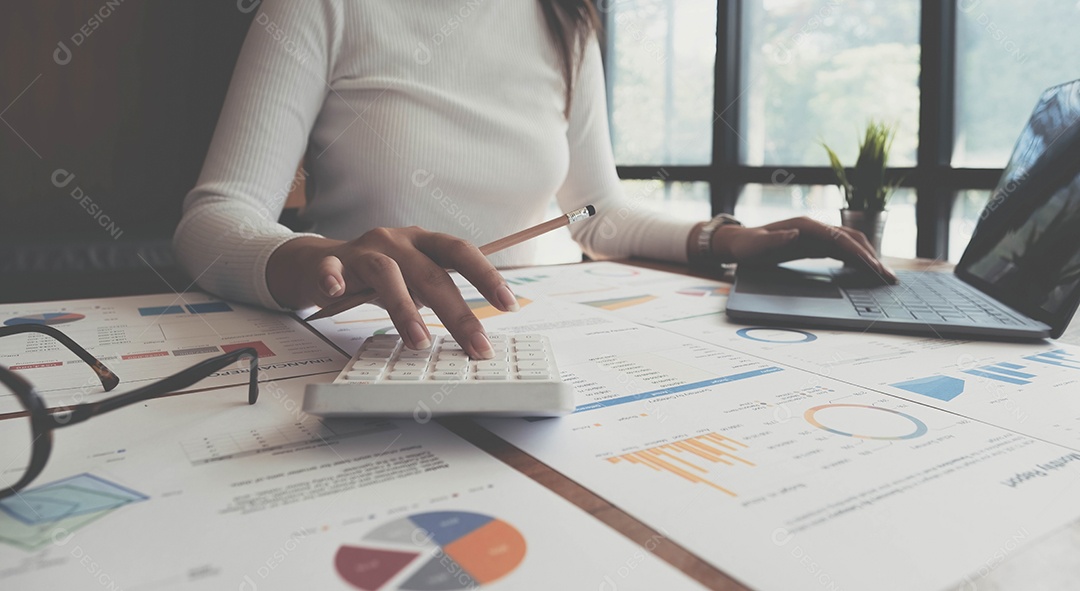 Mulher empresária usando uma calculadora com uma caneta na mão