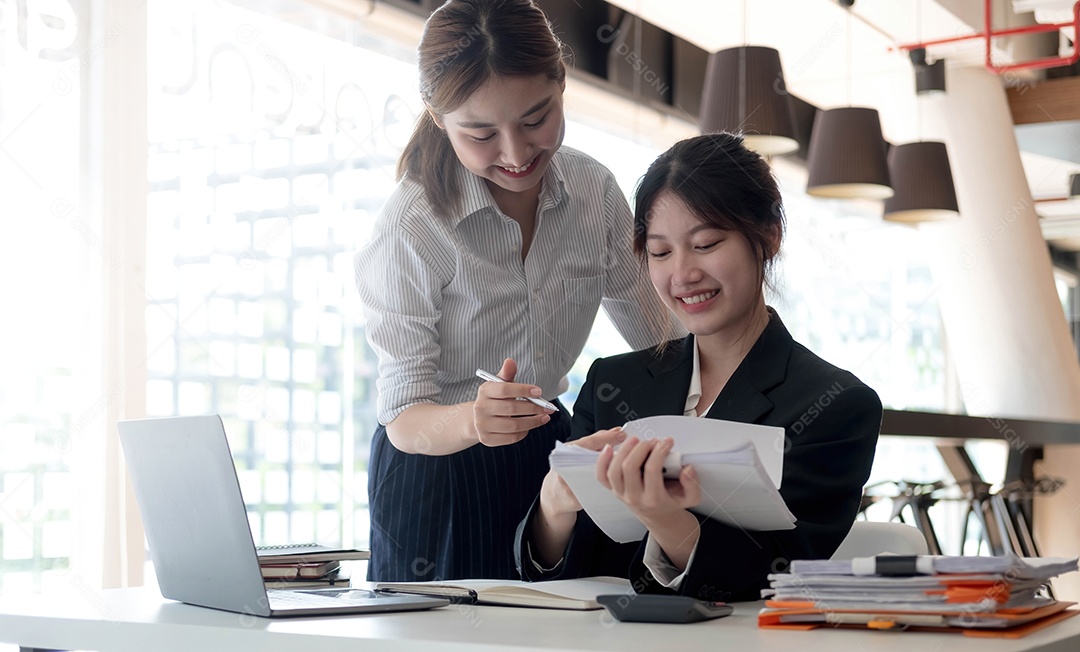 Duas jovens empresárias asiáticas trabalhando juntas em escritórios