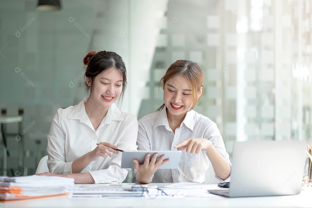 Duas mulheres de negócios asiáticas trabalham juntas para fazer o trabalho