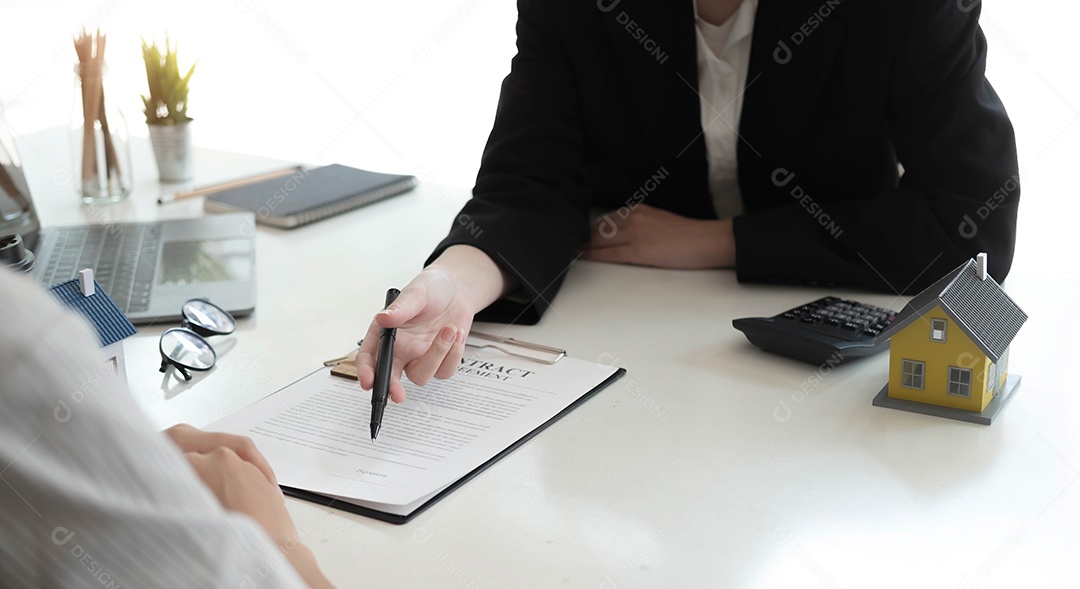 Os agentes imobiliário estão explicados aos clientes que assinam um contrato