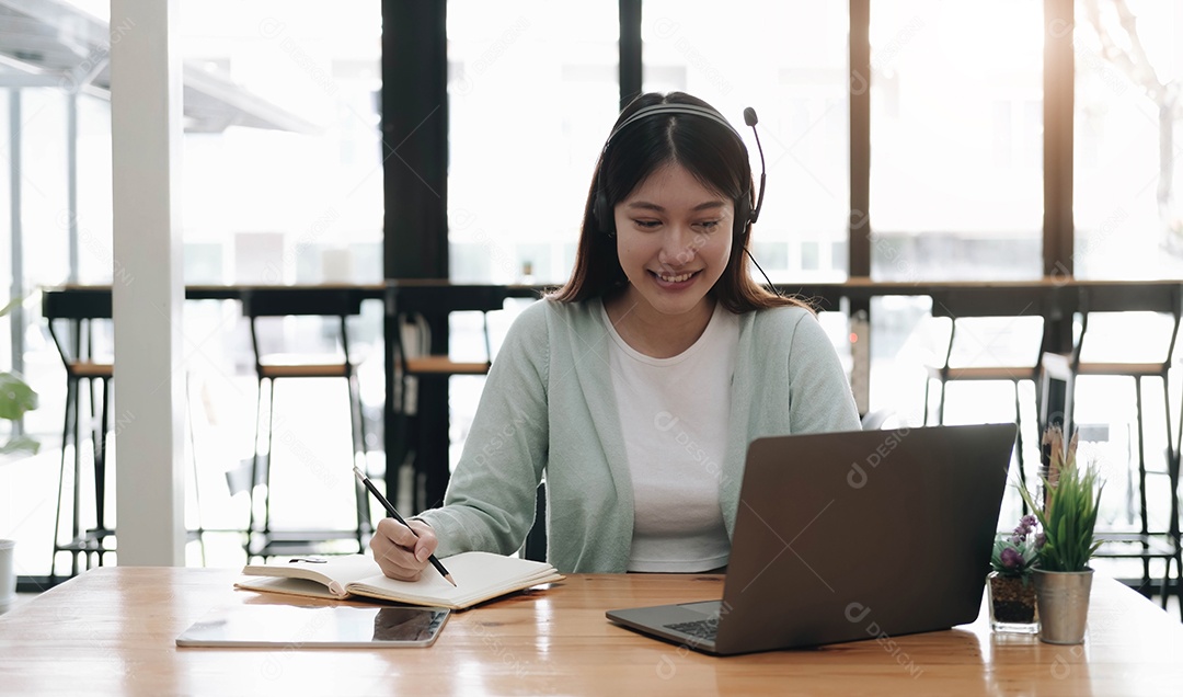 Mulher asiática usando fones de ouvido estuda online