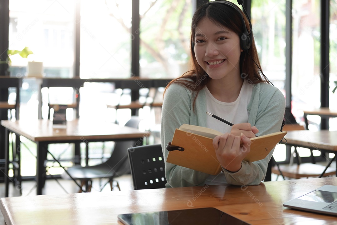 Mulher asiática usando fones de ouvido estuda online