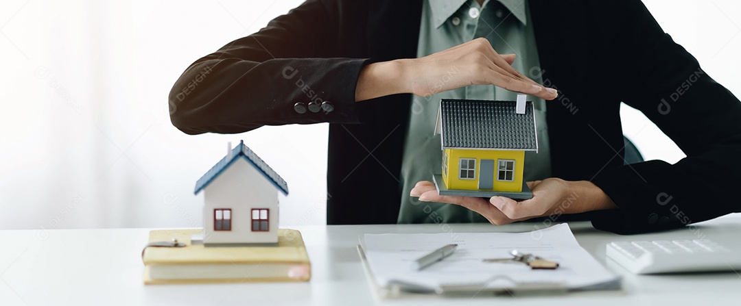 Casa em miniatura nas mãos de uma mulher asiática