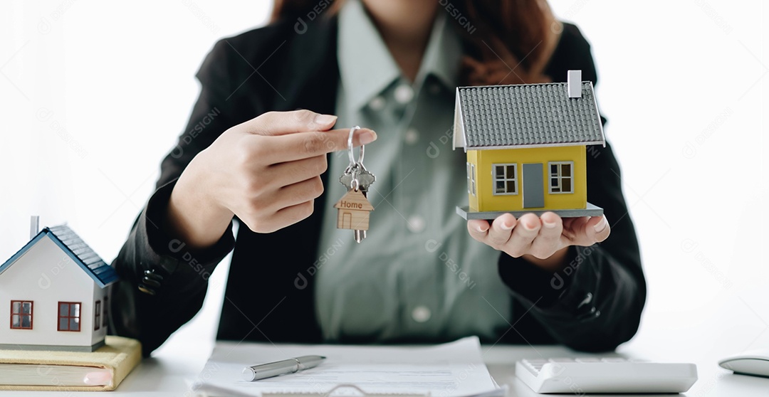 O agente imobiliário está apresentando o empréstimo à habitação e enviando as chaves ao cliente