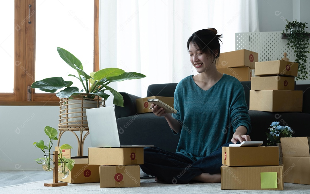 As mulheres asiáticas escrevem notas de pedidos de mercadorias com um sorriso no rosto