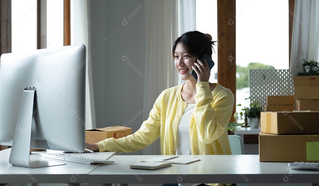 Mulher asiática, funcionária de comércio eletrônico sentada no escritório