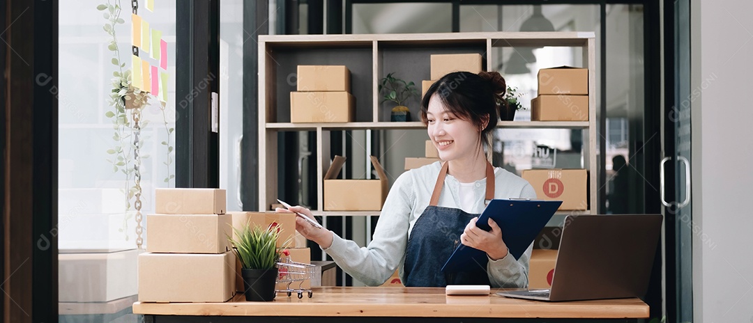 Uma jovem mulher asiática, funcionário de comércio eletrônico sentada