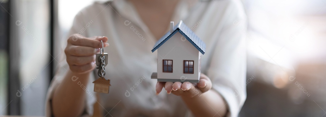 Modelo de casa e chave na mesa para finanças e conceito bancário.