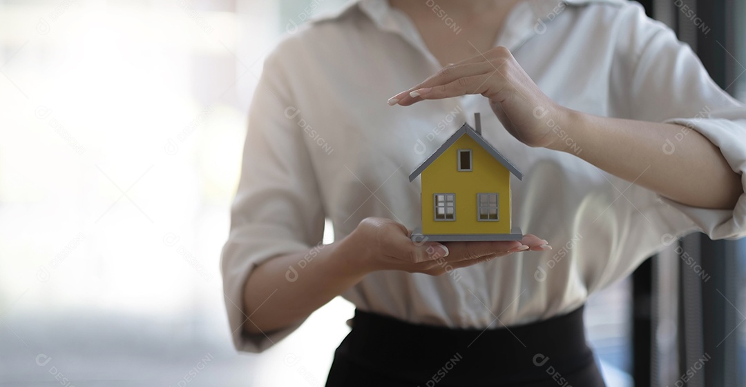 O agente imobiliário usa as mãos para proteger os telhados