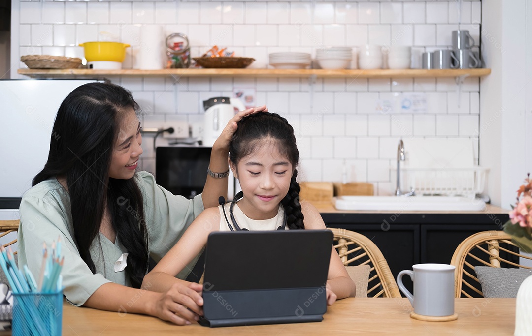 Mãe e criança asiática garotinha aprendendo e olhando para o laptop