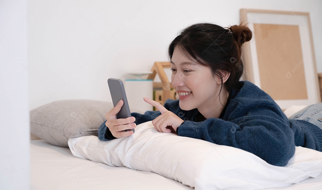 Linda mulher usando um telefone inteligente de manhã na cama em casa