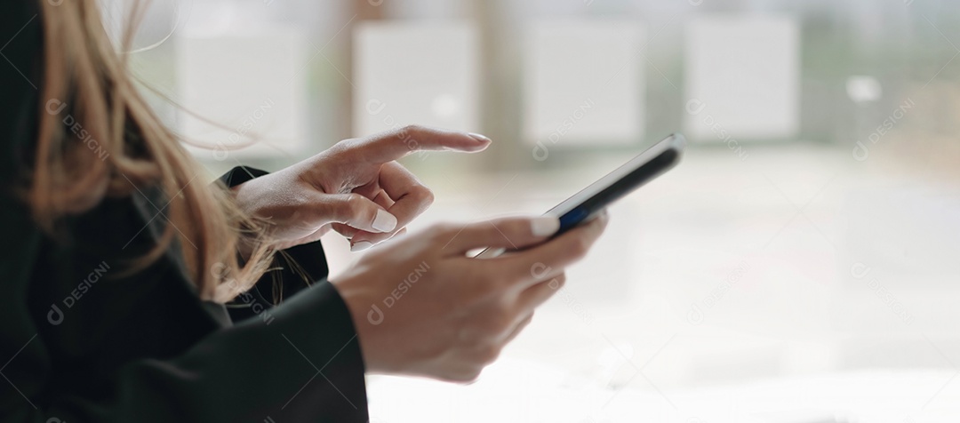 Mão de uma mulher usando smartphone na cafeteria