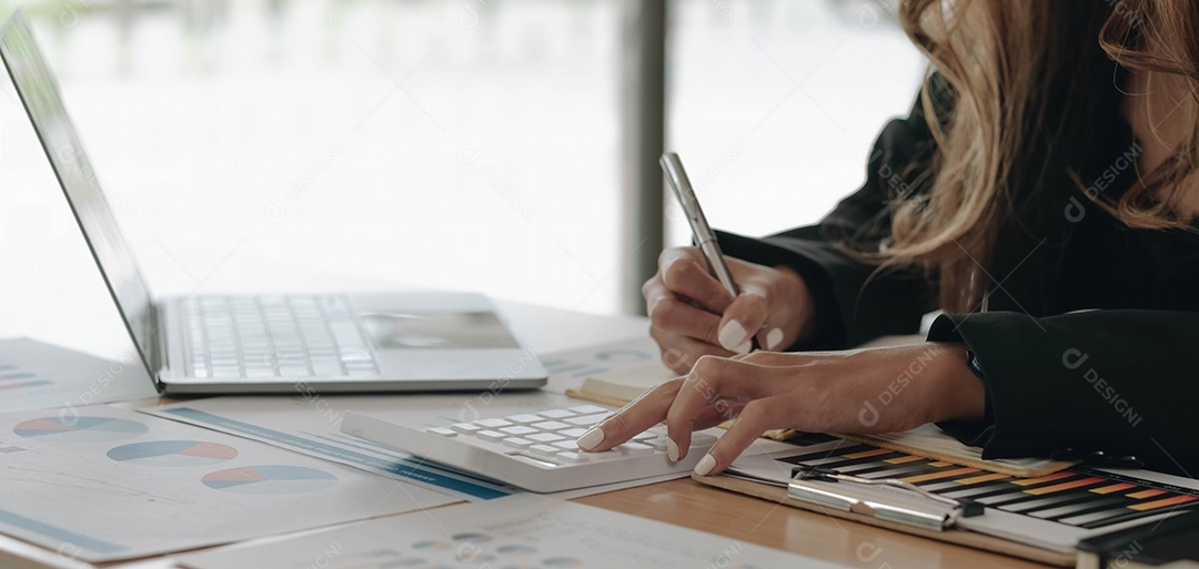 Mão da empresária ou do contador segurando a caneta trabalhando