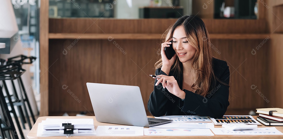 Mulher de negócios asiática tem a alegria de falar ao telefone