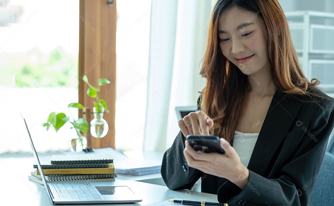 A mulher de negócios asiática tem a alegria de falar ao telefone