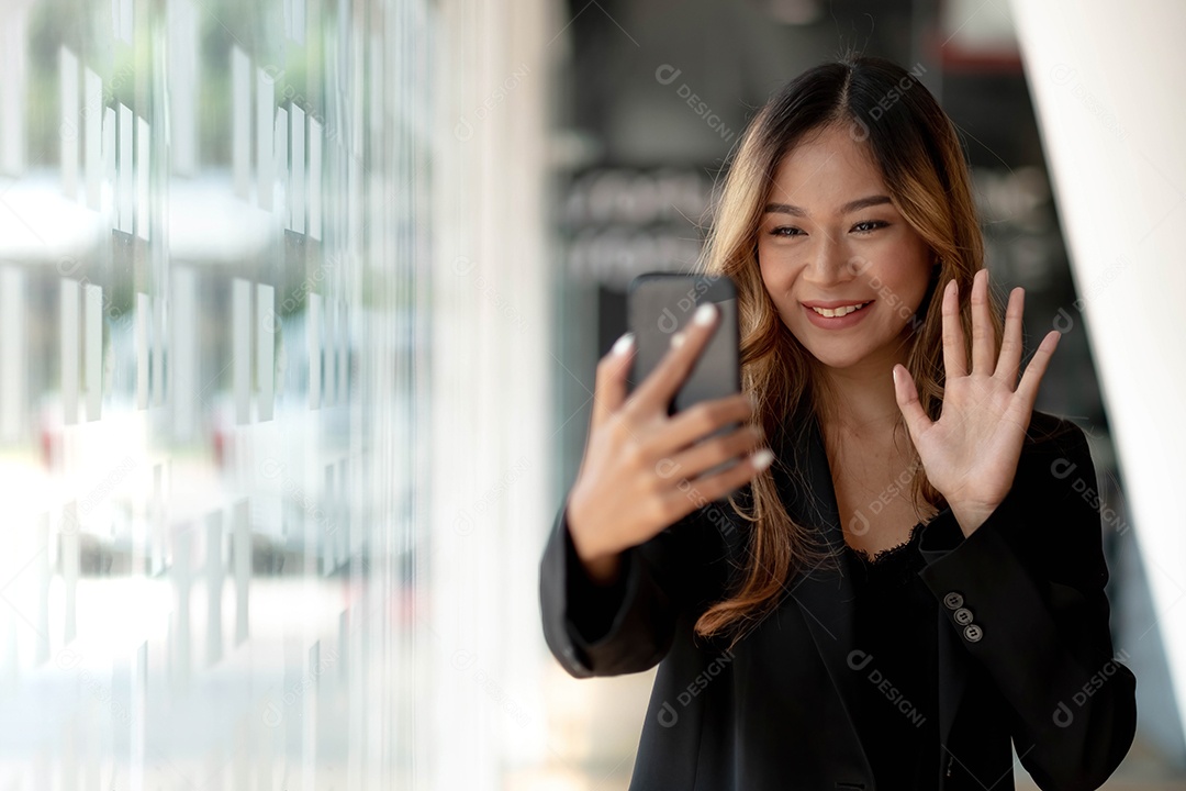 Jovem empresária asiática linda e charmosa sorrindo fazendo uma videochamada