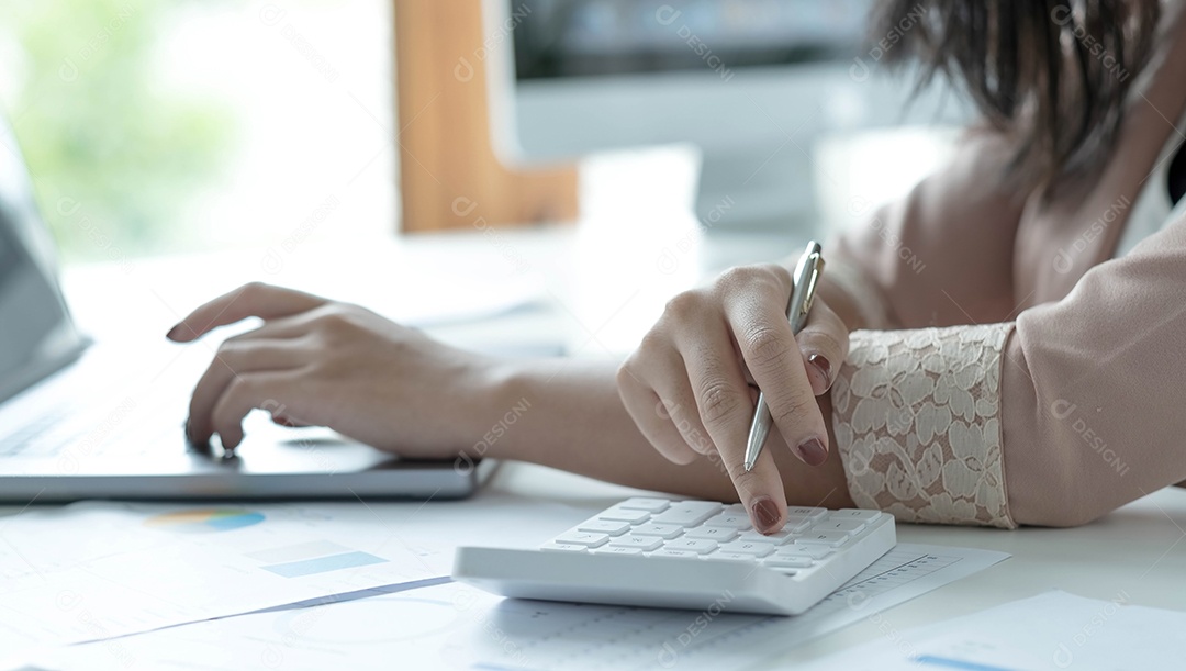 Mulher contadora usa calculadora e computador na mesa do escritório.