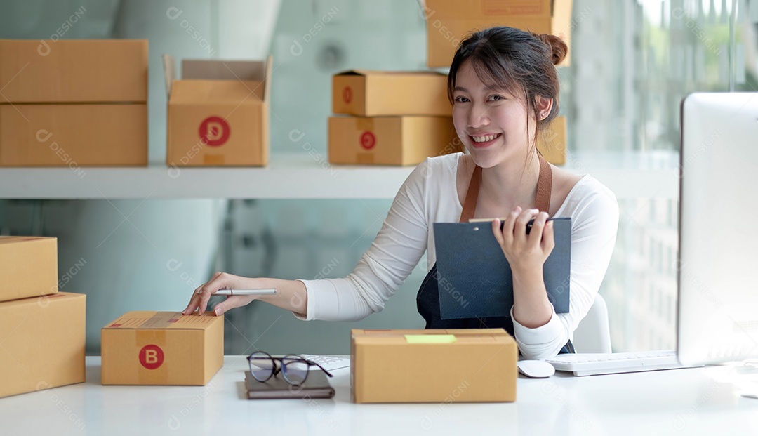 Jovem proprietária asiática olha para o trabalho