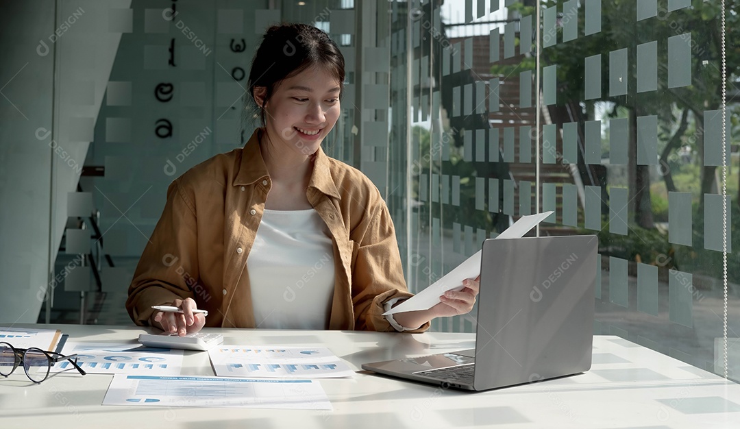 A jovem empresária asiática está feliz em trabalhar no escritório moderno