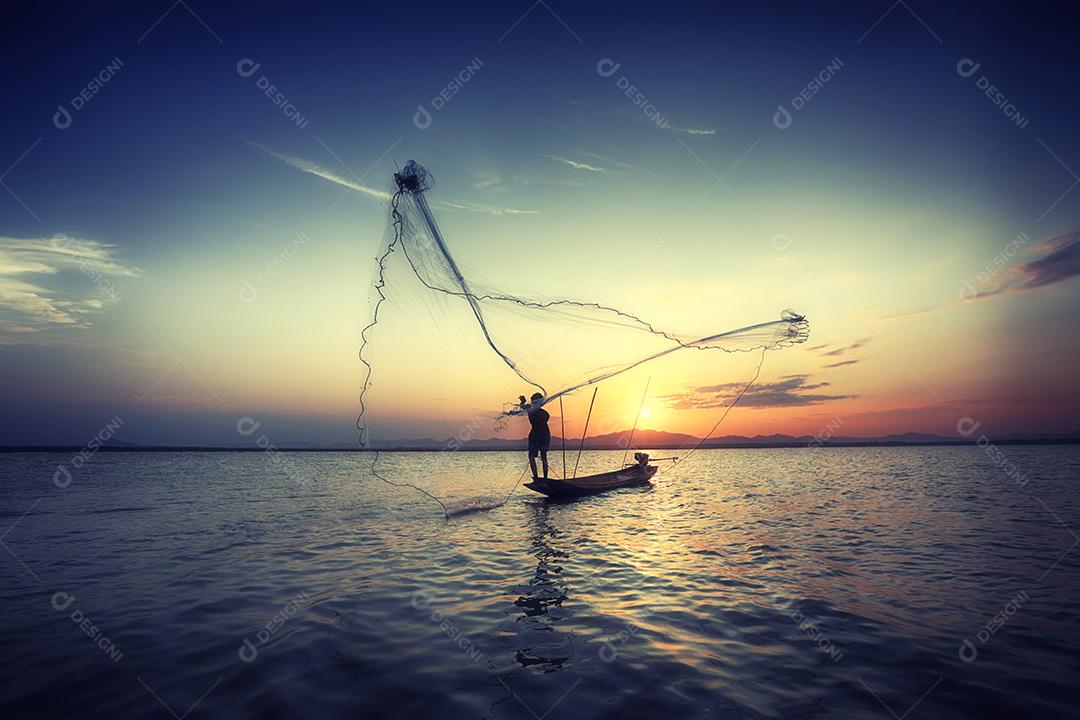 pescador de silhueta e barco no rio durante o pôr do sol, Tailândia