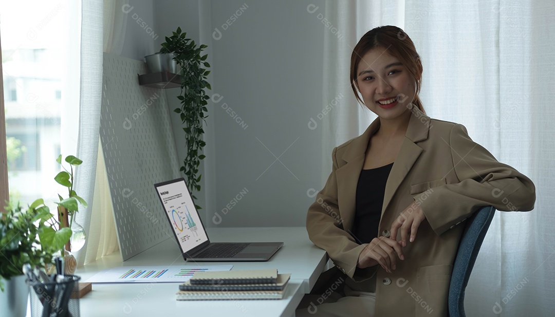 Retrato de uma jovem empresária confiante sentada no local de trabalho moderno