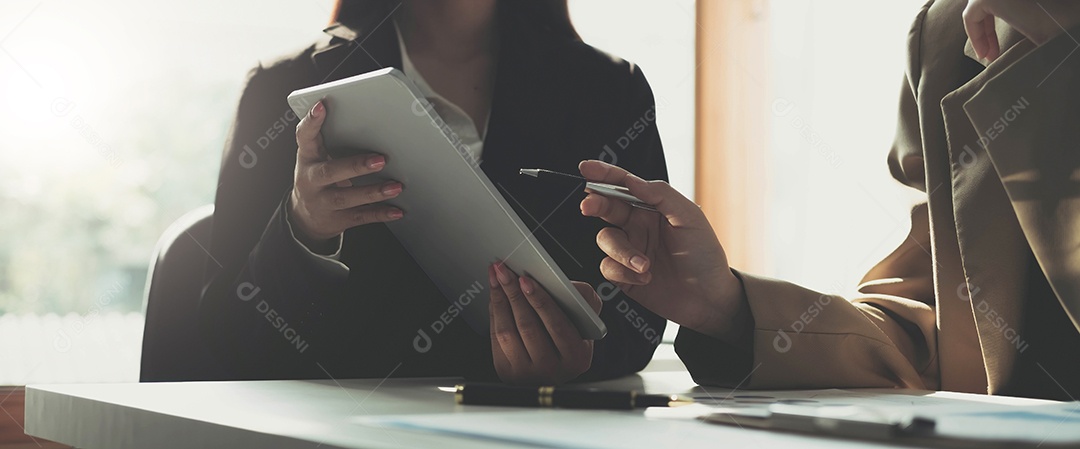 Mãos femininas seguram a caneta e apontam o documento no tablet