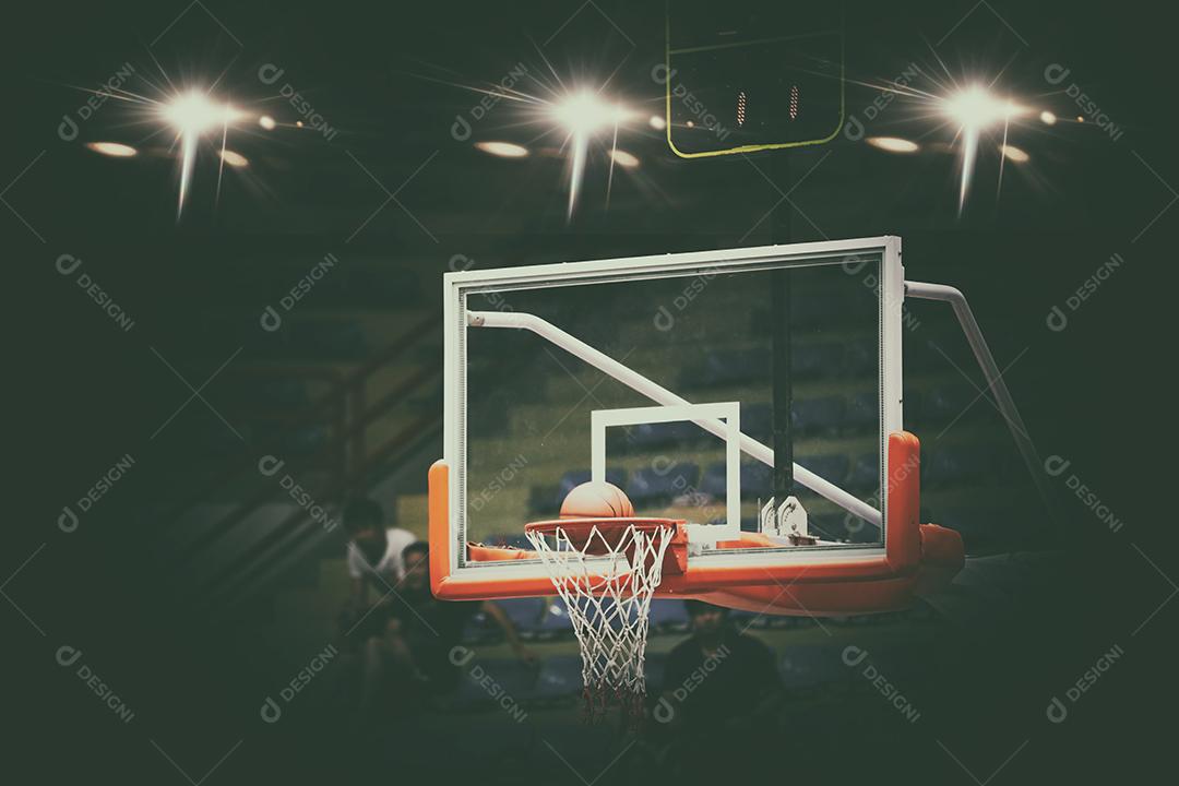 Basquete passando pela rede e marcando durante a partida, foco embaçado e suave